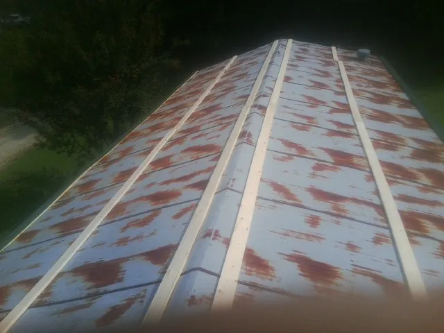 Rusted metal roof panels with new wood purlins before replacement — Storm Damage Roof Repair in Lexington Park by Roofing Brothers