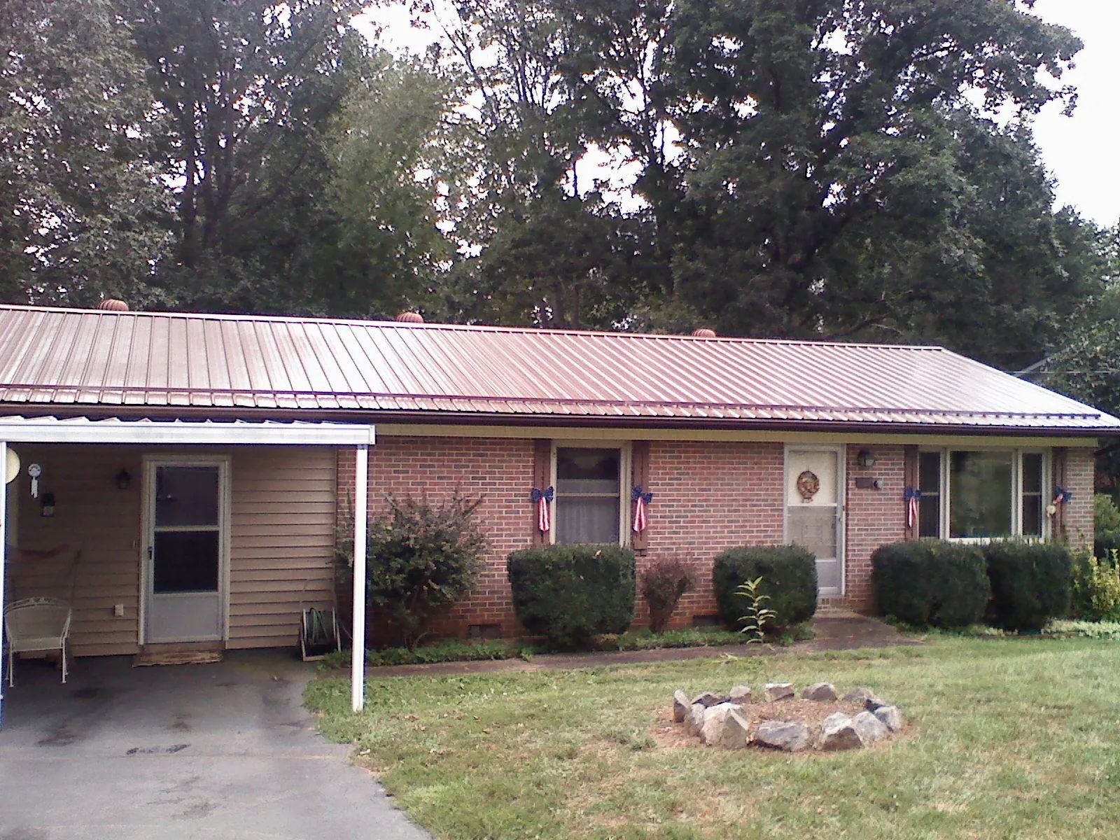 Bronze metal roof and carport on a brick ranch home — Roof Repair work by our crew in Lexington Park